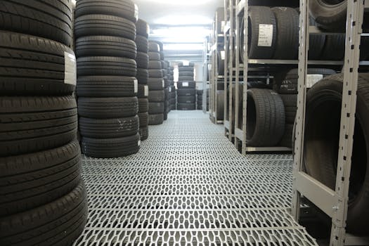 Rows of stacked tires in an indoor industrial warehouse for storage.